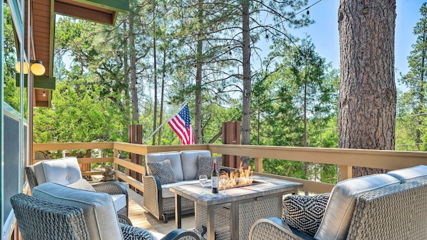 An outdoor deck with wicker furniture, a fire pit, and an American flag. - Cabin < Half-mi From Pine Mountain Lake Marina! (Groveland)