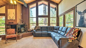 A large L-shaped leather sectional sofa, a fireplace, and a large window with a deer print on the wall. - Cabin < Half-mi From Pine Mountain Lake Marina! (Groveland)