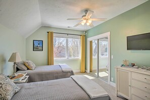 A bedroom with two beds, a ceiling fan, a TV, and a window with curtains. - Dtwn Ludington Apt w/ Fire Pit: Day Trip to Slopes (Ludington)