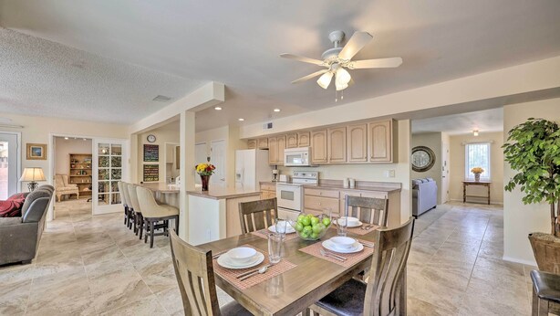 A spacious living room with a dining area, a kitchen, and a hallway leading to bedrooms. - Quiet Sun City Home w/ Grill - Golf & Hike Nearby! (Sun City)