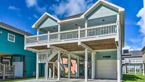 Ein zweigeschossiges Haus mit verdeckter Veranda, einer Garage und einer Treppe, die zum Obergeschoss führt.