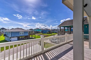 A residential area with houses on stilts, a wooden deck, and a clear sky. - Walk to Shore: Family Retreat in Crystal Beach! (Port Bolivar)
