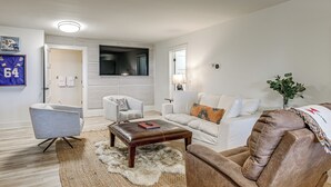 A living room with a sofa, armchairs, a coffee table, and a television. - Ski & Unwind Fireside: Highlands Gem w/ Game Room! (Highlands)