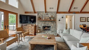 A spacious living room with a stone fireplace, a television, and a cozy seating area. - Ski & Unwind Fireside: Highlands Gem w/ Game Room! (Highlands)