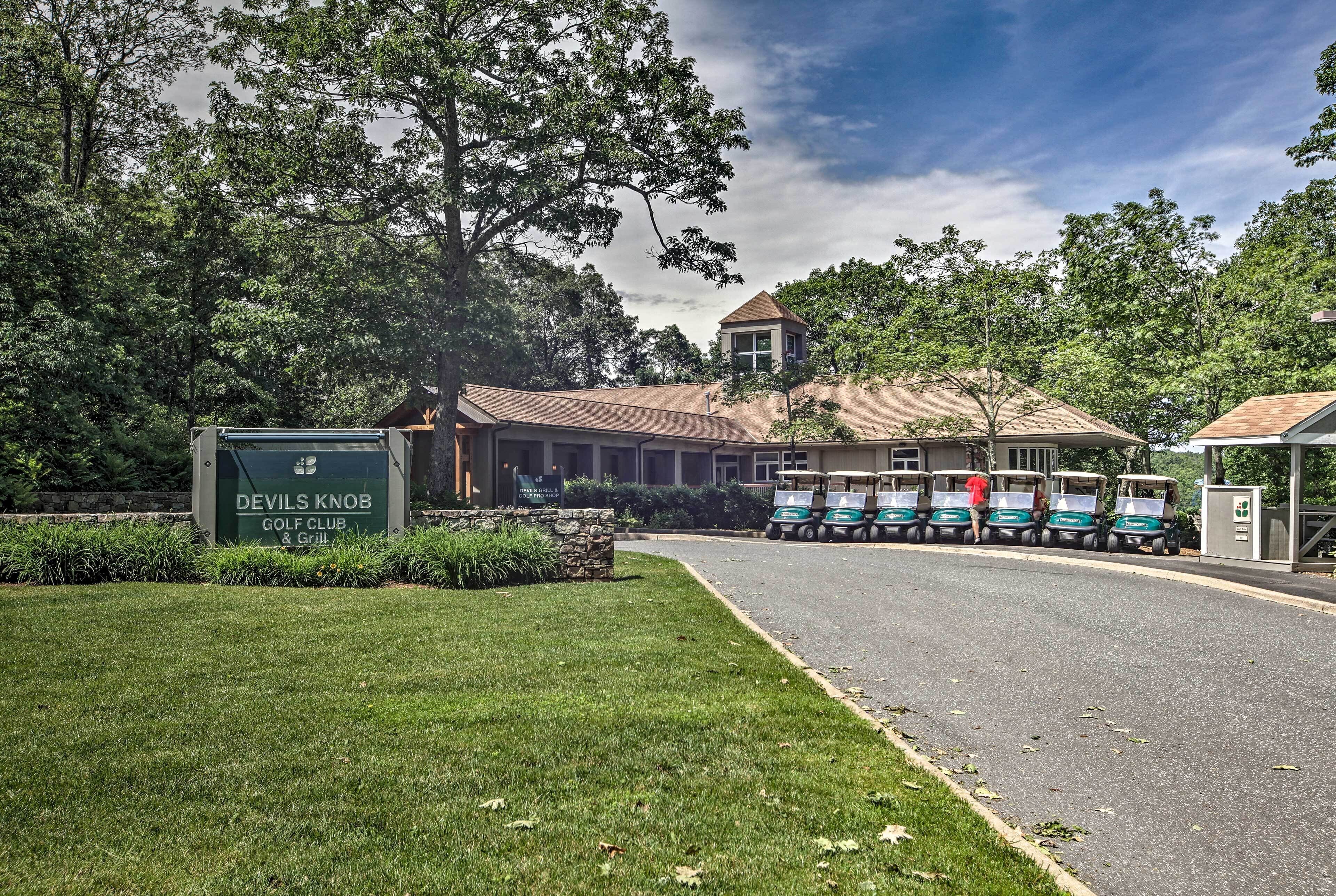 Un club de golf con un letrero, un edificio y carritos de golf.
