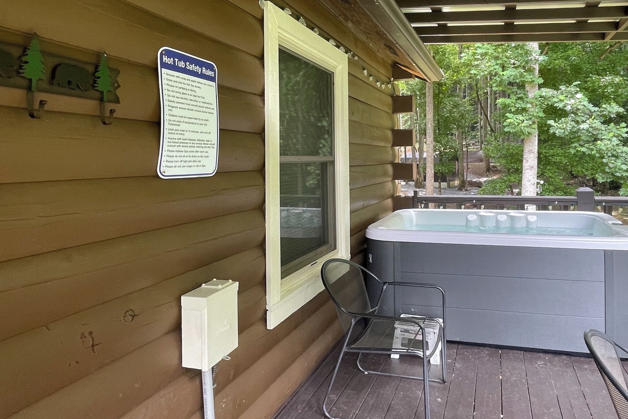 Ein Whirlpool mit einem Sicherheitsschild auf einer Holzterrasse.