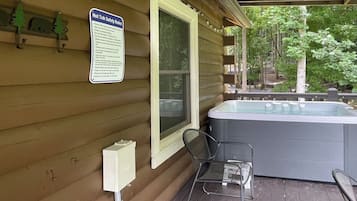 Ein Whirlpool mit einem Sicherheitsschild auf einer Holzterrasse.