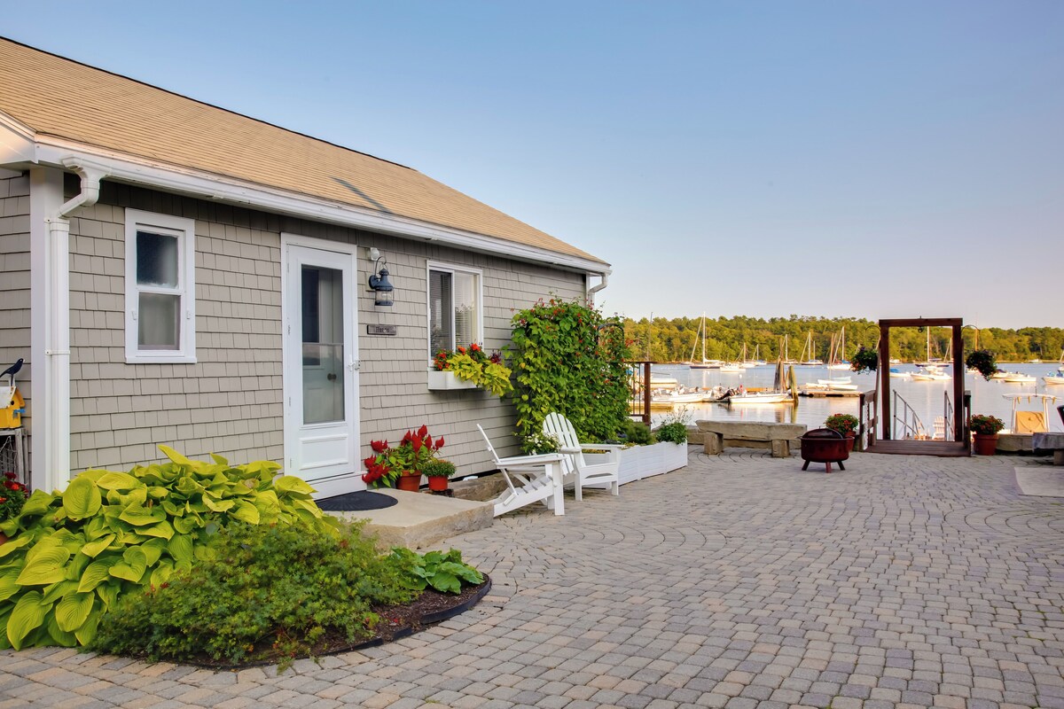 A house with a patio area, a white door, and a view of boats on the water.