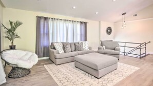 A modern living room with a sectional sofa, a chaise lounge, and a small ottoman.