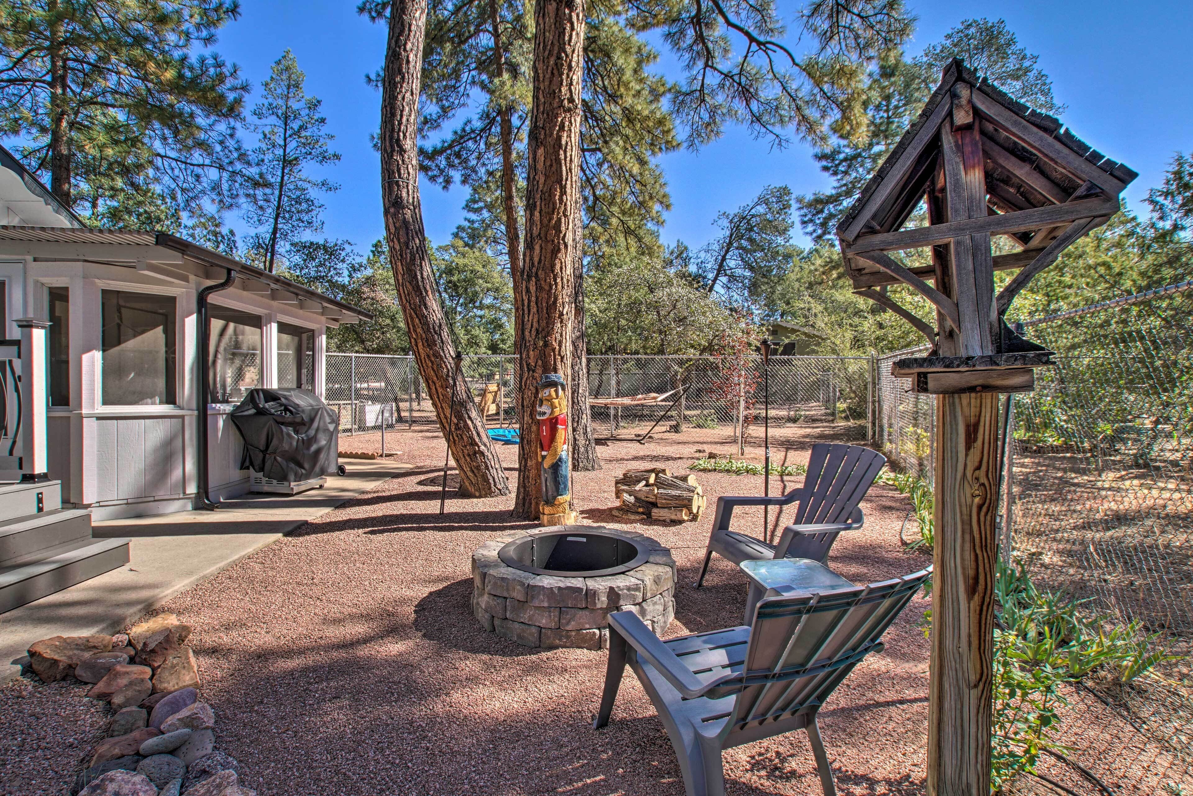 Un patio couvert avec un foyer, des sièges d’extérieur et une structure en bois.