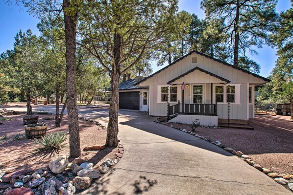 A single-story house with a front porch, surrounded by trees and a gravel driveway. - Peaceful Deck + Fire Pit: Payson Home! (Payson)
