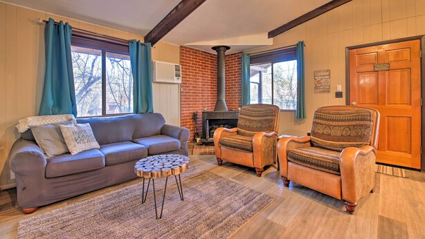 A cozy living room with a fireplace, a sofa, two armchairs, and a round coffee table.
