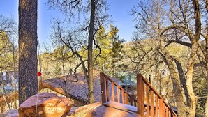 A wooden staircase leading up a rocky hill in a forested area.