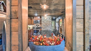 Eine Küche mit Holzwänden, einer Wand aus Stein und einer zentralen Kochinsel mit dekorativer Dekoration.