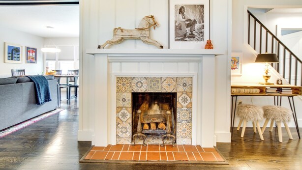 Una sala de estar con chimenea, un sofá y un comedor con mesa y sillas.