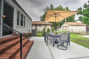 Enjoy al fresco dining on the patio, surrounded by a charming garden and a brick staircase leading to the front door.