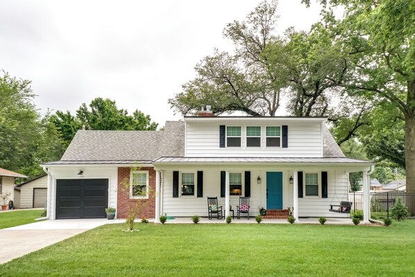Stroll up to this charming home, featuring a cozy porch and beautifully manicured lawn.
