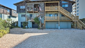 A multi-story building with a wooden staircase and a garage.