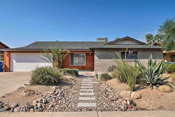 A modern two-story house with a garage, a stone facade, and a landscaped front yard with a pathway and various plants. - Fire Pit, Heated Pool: Central Tempe Escape! (Tempe)