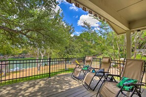 Une terrasse couverte, aménagée avec du mobilier d’extérieur, et offrant une vue sur un lac.