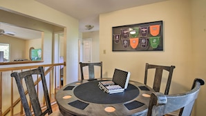 A dining area with a round table, four chairs, and a framed collection of sports pennants on the wall. - Lake Placid Paradise w/ Dock, Grill & Kayaks! (Seguin)