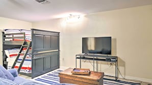 A room with bunk beds, a television, a small table, and a light fixture. - Lake Placid Paradise w/ Dock, Grill & Kayaks! (Seguin)