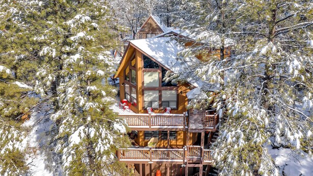 A wooden cabin with a balcony, surrounded by snow-covered trees. - Pet-friendly Munds Park Retreat w/ Wraparound Deck (Munds Park)