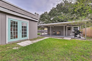 A house with a covered patio area, a garage, and a lawn.