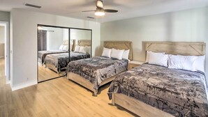 A bedroom with two beds, a ceiling fan, and a large mirror. - Modern Lake Havasu Retreat: Lake & Mountain Views! (Lake Havasu City)