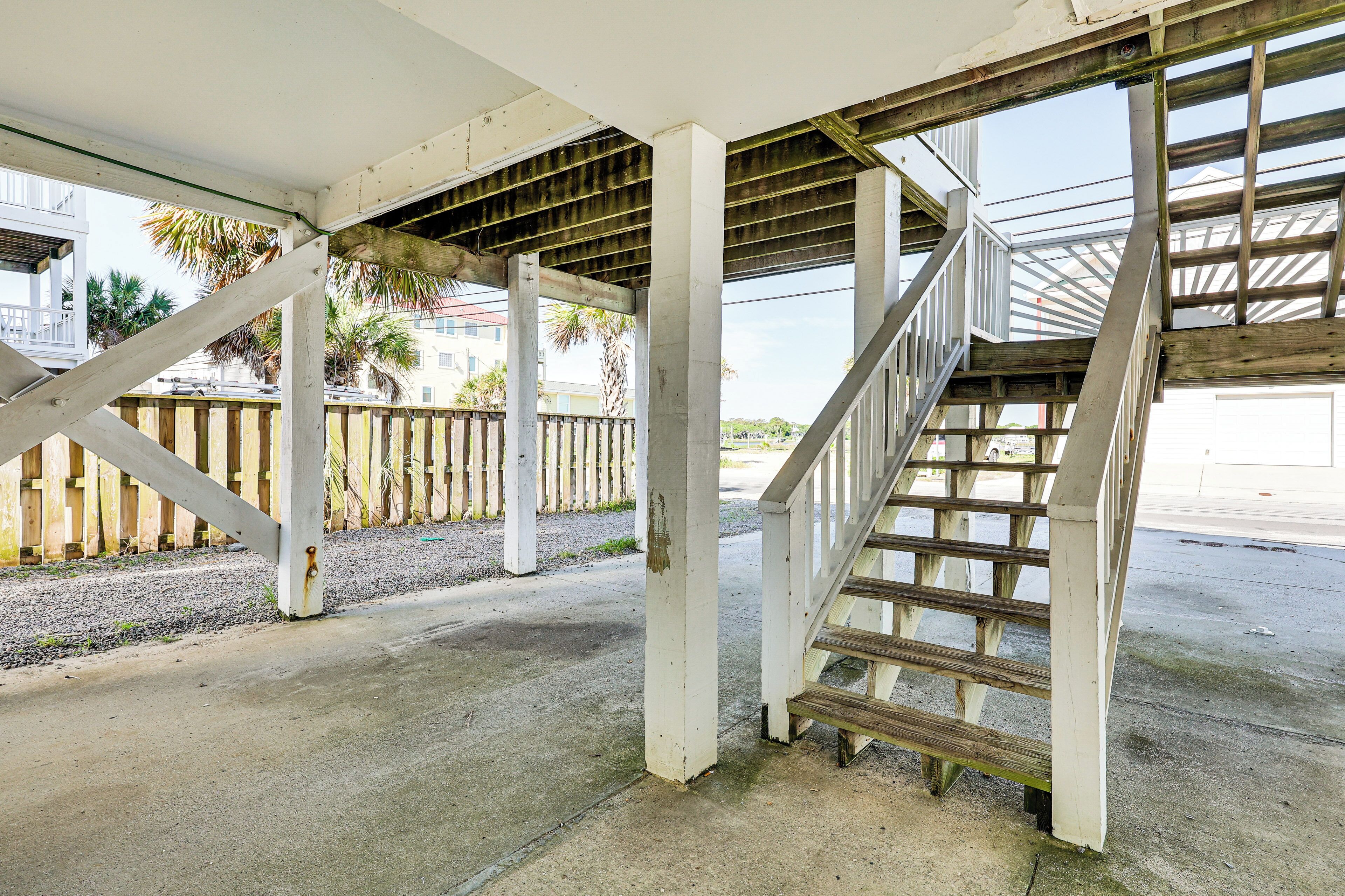 Un espace extérieur abrité doté d’un sol en béton, de rampes en bois et d’un escalier.
