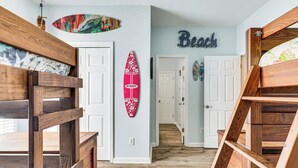 Ein Flur mit Holzkatakrajten, einem Surfbrett und einem Schild mit der Aufschrift 'Beach'.
