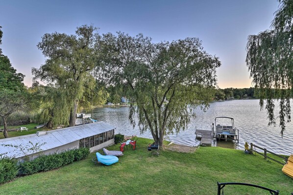 Une propriété au bord du lac, dotée d’un patio couvert, d’un espace salon extérieur et d’un quai.