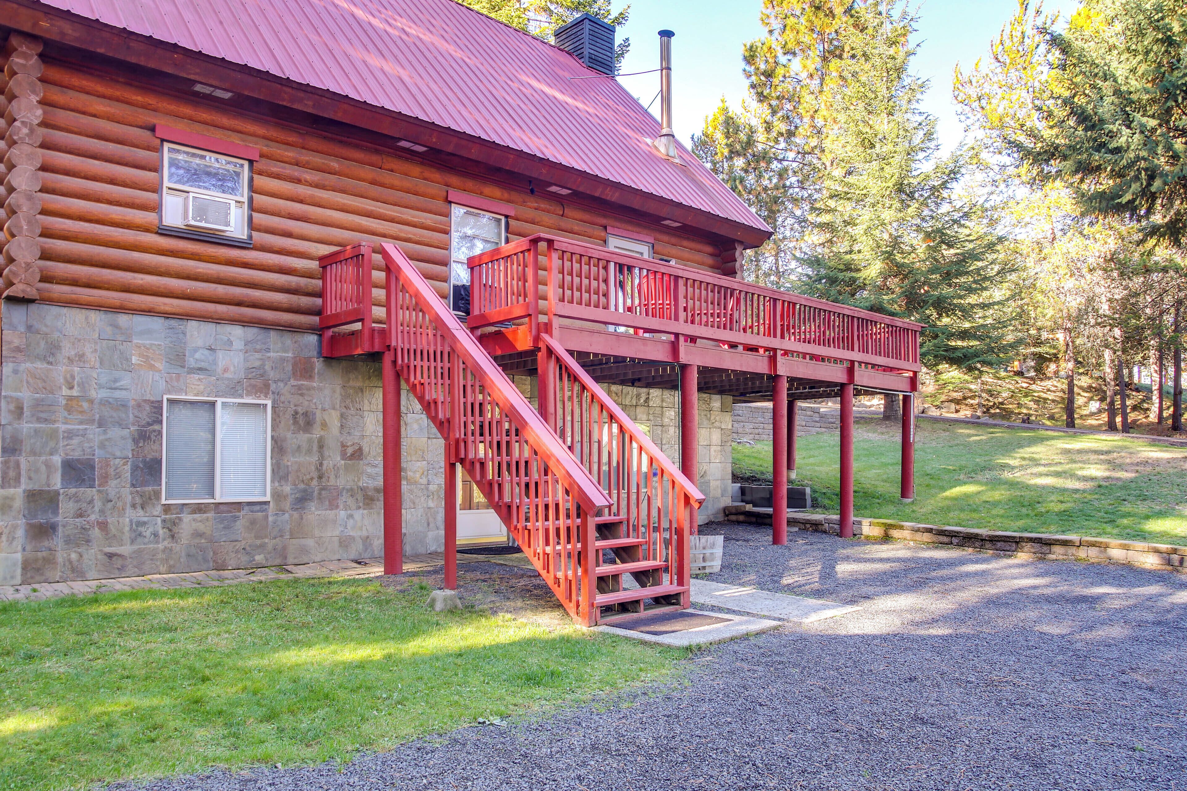 A log cabin with a red staircase leading to a balcony.