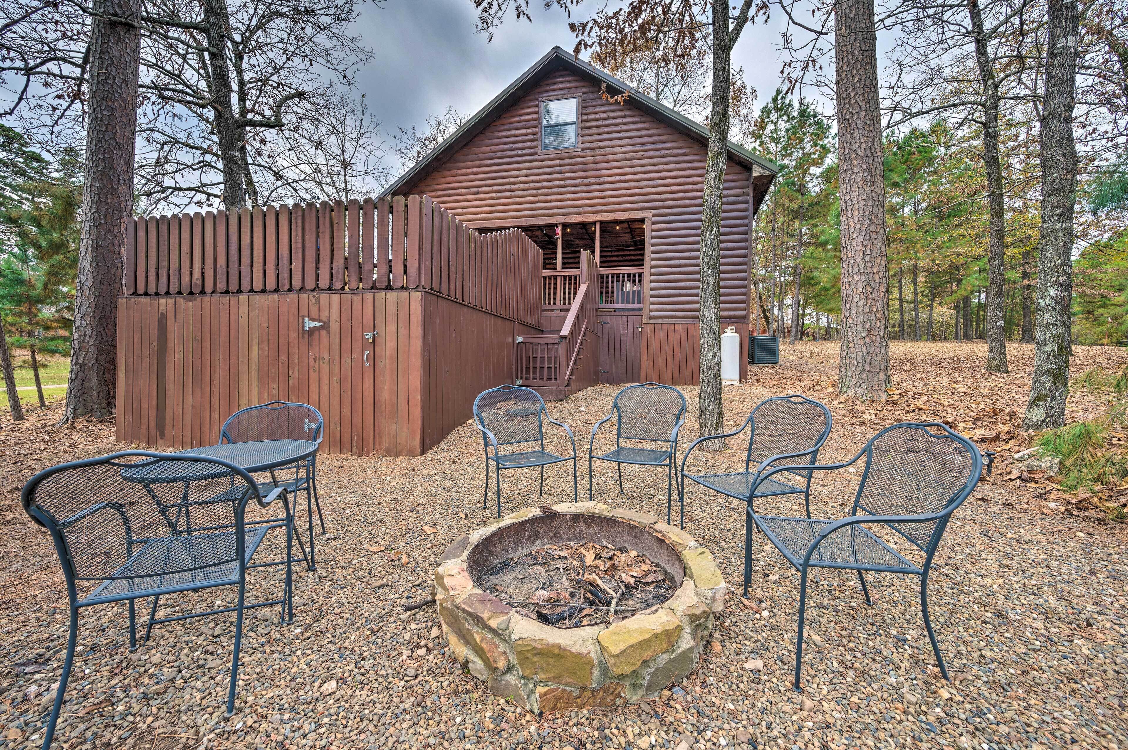 Un chalet rustique doté d’une terrasse en bois, d’un foyer extérieur et de meubles de jardin.
