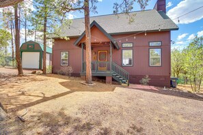 A two-story building with a porch, a covered entryway, and a staircase leading to the upper floor.