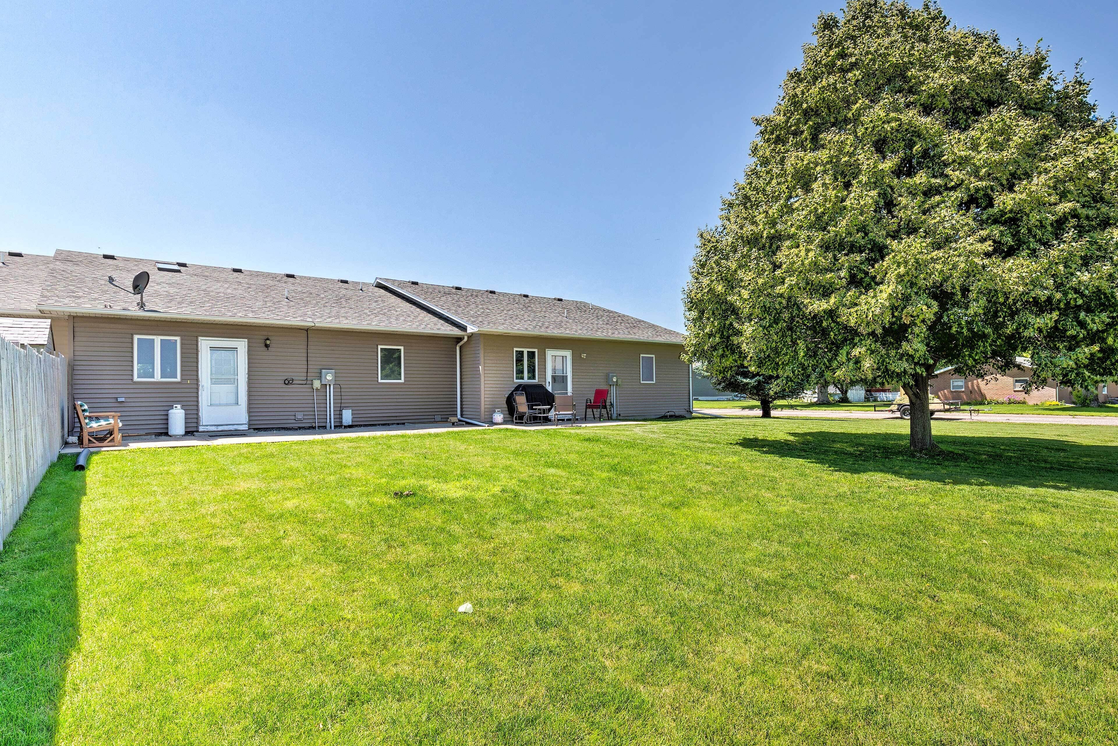 A two-story building with a flat roof, a covered patio area, and a well-maintained lawn.