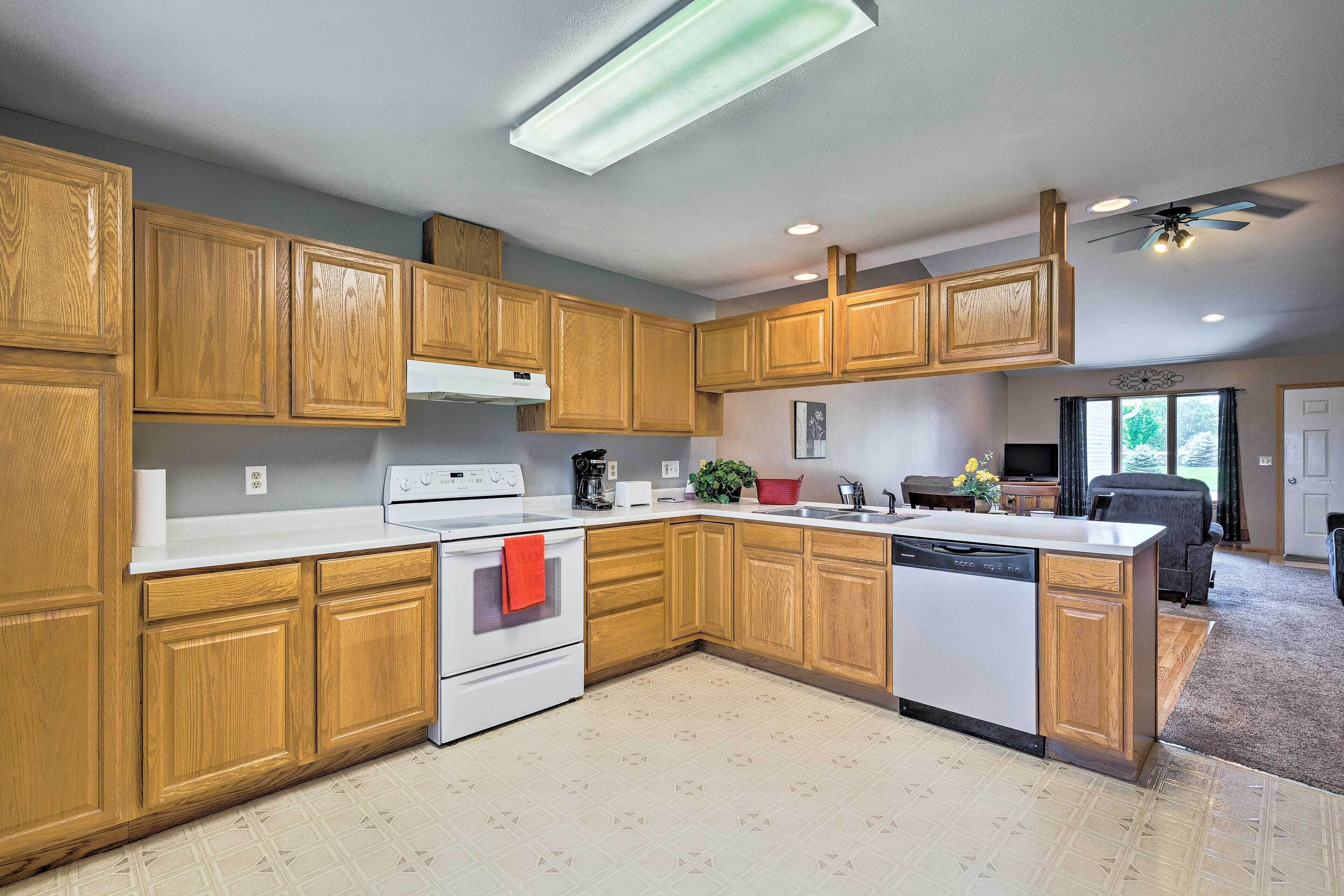 A modern kitchen with wooden cabinets, a white countertop, and a built-in dishwasher.
