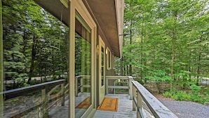 A wooden deck with glass doors leading to a forested area. - Home in Big Bass Lake Community: Fire Pit & Grill! (Gouldsboro)