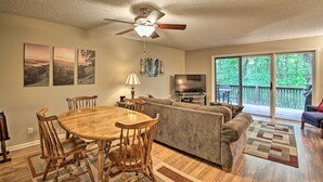 A dining area with a wooden table and chairs, a ceiling fan, and a TV in the background. - 3 Mi to Golf: Hot Springs Village Retreat w/ Deck (Hot Springs Village)