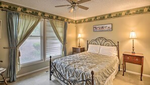 A bedroom with a bed, two bedside tables with lamps, a ceiling fan, and a window with curtains. - 3 Mi to Golf: Hot Springs Village Retreat w/ Deck (Hot Springs Village)
