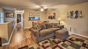 A living room with a sectional sofa, a dining area with a table and chairs, and a kitchen in the background. - 3 Mi to Golf: Hot Springs Village Retreat w/ Deck (Hot Springs Village)