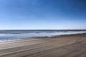 A beach with a wide sandy shore and calm water.
