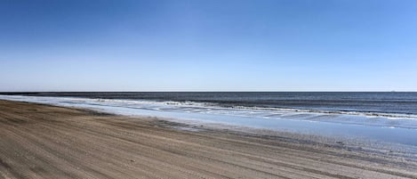 A beach with a clear sky and ocean waves.