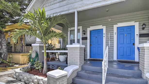 A house with two blue doors, a covered porch, and a small palm tree. - Updated Ybor City House w/ Fenced Yard (Tampa)