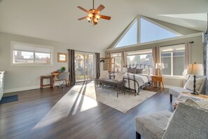 A spacious living room with a high ceiling, large windows, and a ceiling fan. - Charming Getaway, Walk to Windsor Lake & Downtown! (Windsor)