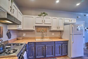 A kitchen with white cabinets, a stainless steel stove, and a white refrigerator. - Luxe Route 66 Getaway w/ A/C in Downtown Williams! (Williams)