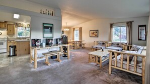 Un grand salon agrémenté de meubles en bois, une cuisine équipée d’une cuisinière et une table à manger.