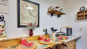 Una cocina con mostrador de madera, un mapa en la pared y diversos utensilios de cocina.