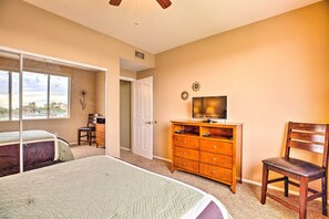 A bedroom with a bed, a dresser, a chair, and a television.