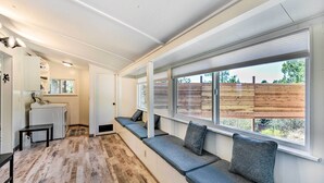 A modern interior with a long bench seating area, a laundry station, and large windows offering a view of the outdoors. - Sedona Stardust Hideaway' w/ Patio & Mtn Views! (Sedona)
